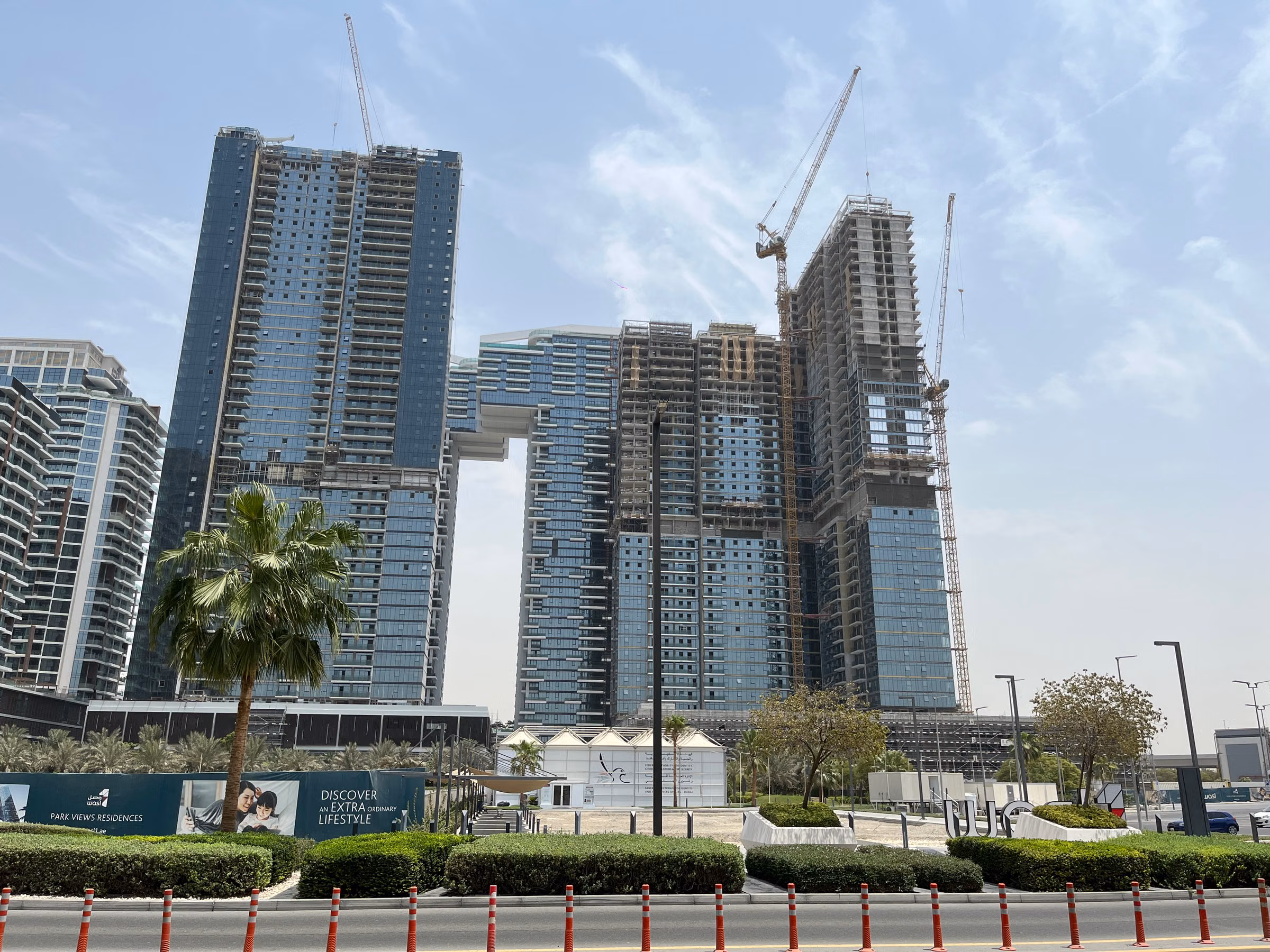 Modern Dubai residential towers under construction with cranes, editorial city photograph